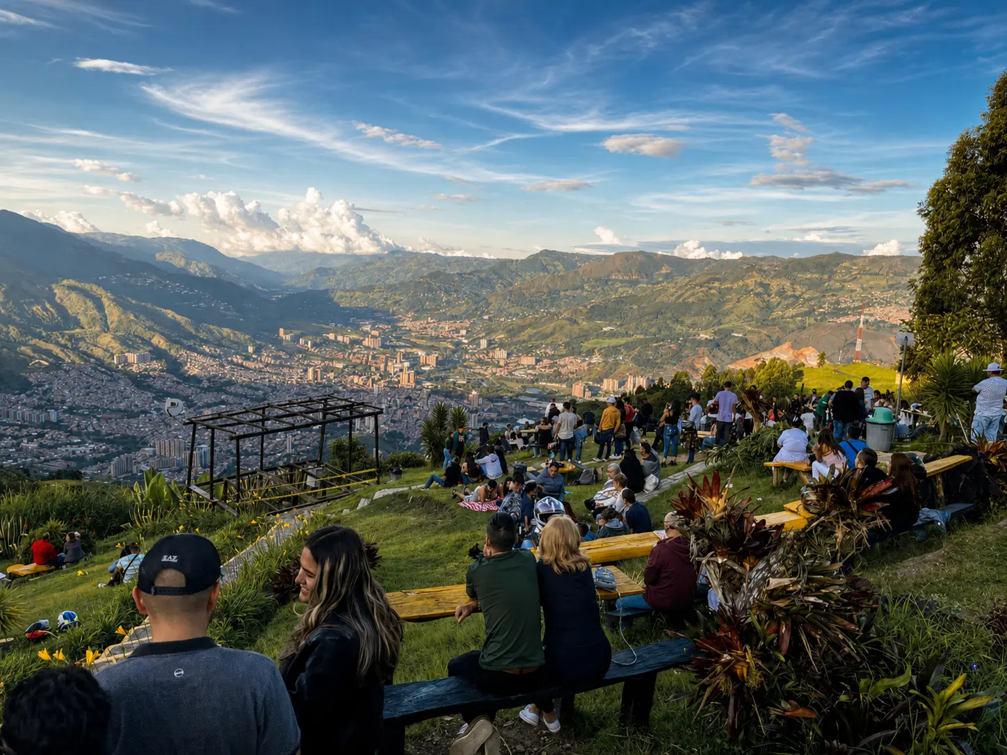A group of people gathered at a hillside viewpoint above Medellín