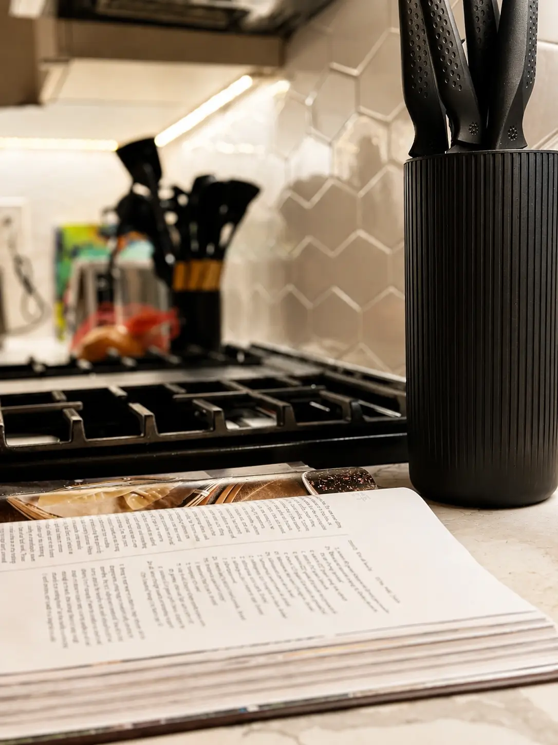 Kitchen detail at Alexander Residence: warm surfaces, plants and everyday utensils