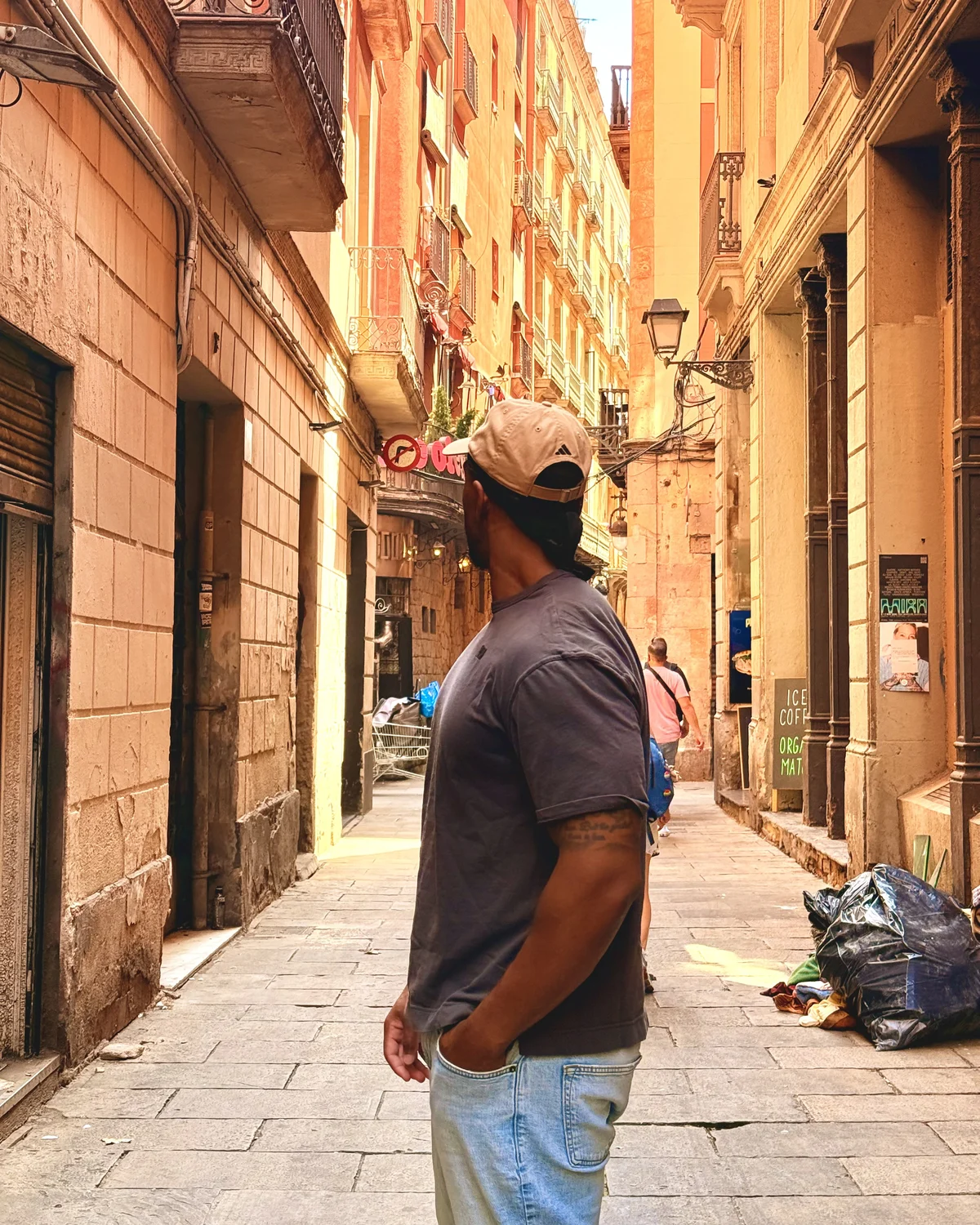 Jonathan standing in a sunlit Barcelona side street, looking up at the balconies above