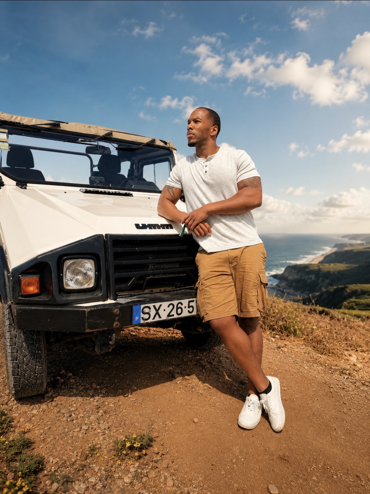 Jonathan standing beside an open Jeep on a coastal road
